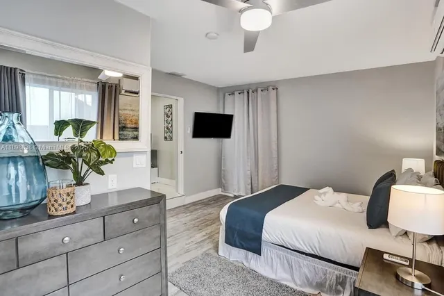 a bedroom with a bed potted plant on the dresser and a potted plant