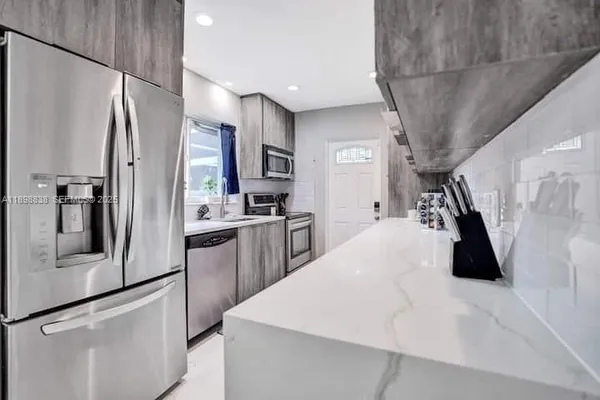 a kitchen with stainless steel appliances a refrigerator and a stove top oven