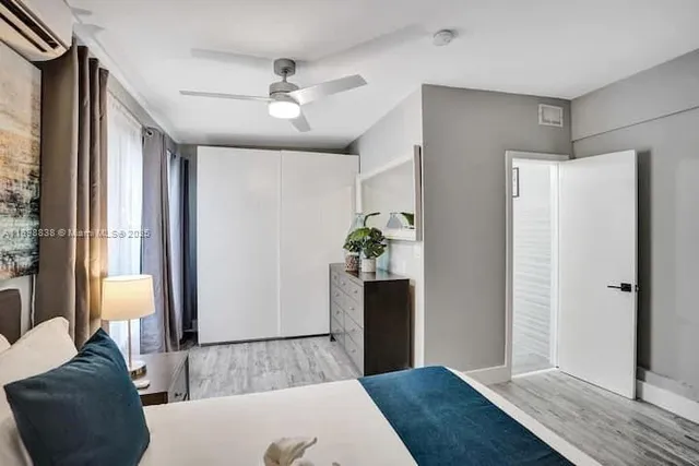 a bedroom with a bed dresser and a large mirror