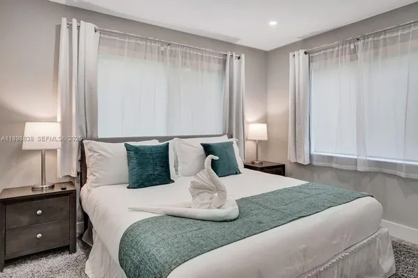 a bedroom with a large bed and a chandelier