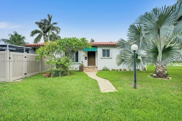 a view of a house with a yard and a palm tree