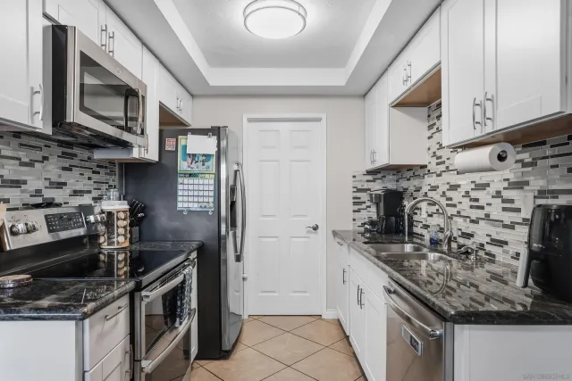 a kitchen with stainless steel appliances granite countertop a stove and a microwave
