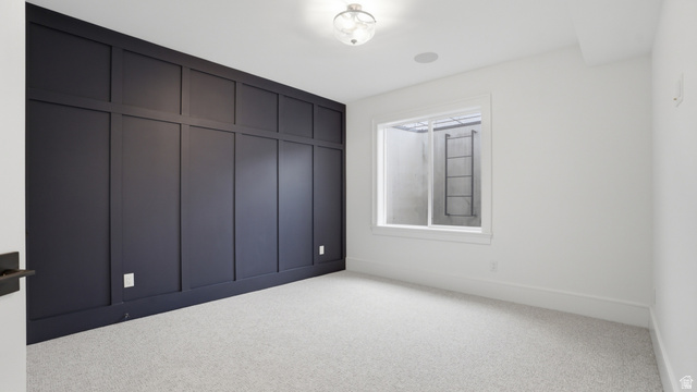 1682 North 1950 W Street, Unit 9 Provo, UT 84604 - Photo 48 of 84 Accent wall with dark wainscoting and trim, light gray textured carpet, recessed ceiling speaker, ceiling-mounted light fixture, and white window trim