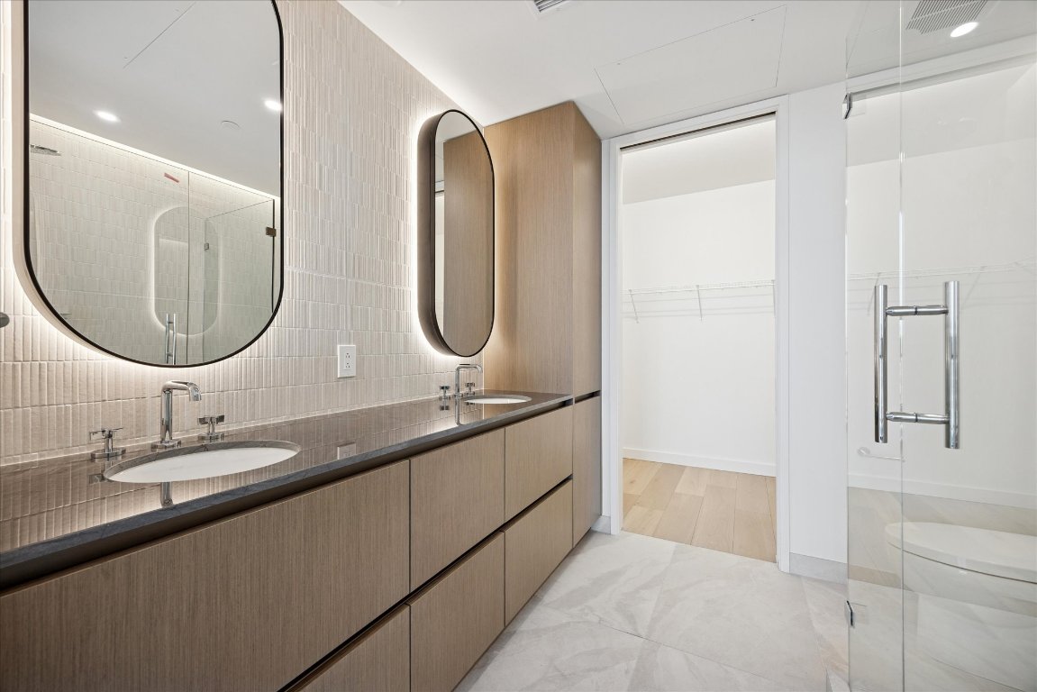 610 Davis Street, Unit 5007 Austin, TX 78701 - Photo 4 of 33 Primary Bathroom with double vanity, a stall shower, a spacious closet, tasteful backsplash, and recessed lighting