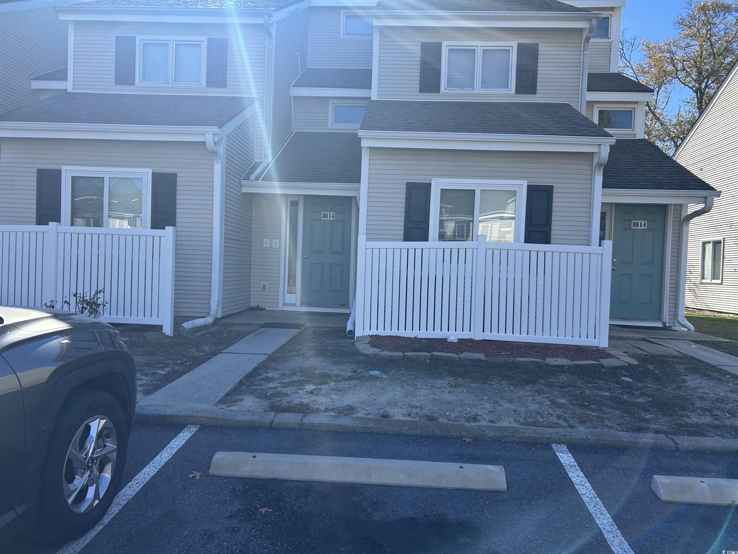 View of front facade with a shingled roof and uncovered parking