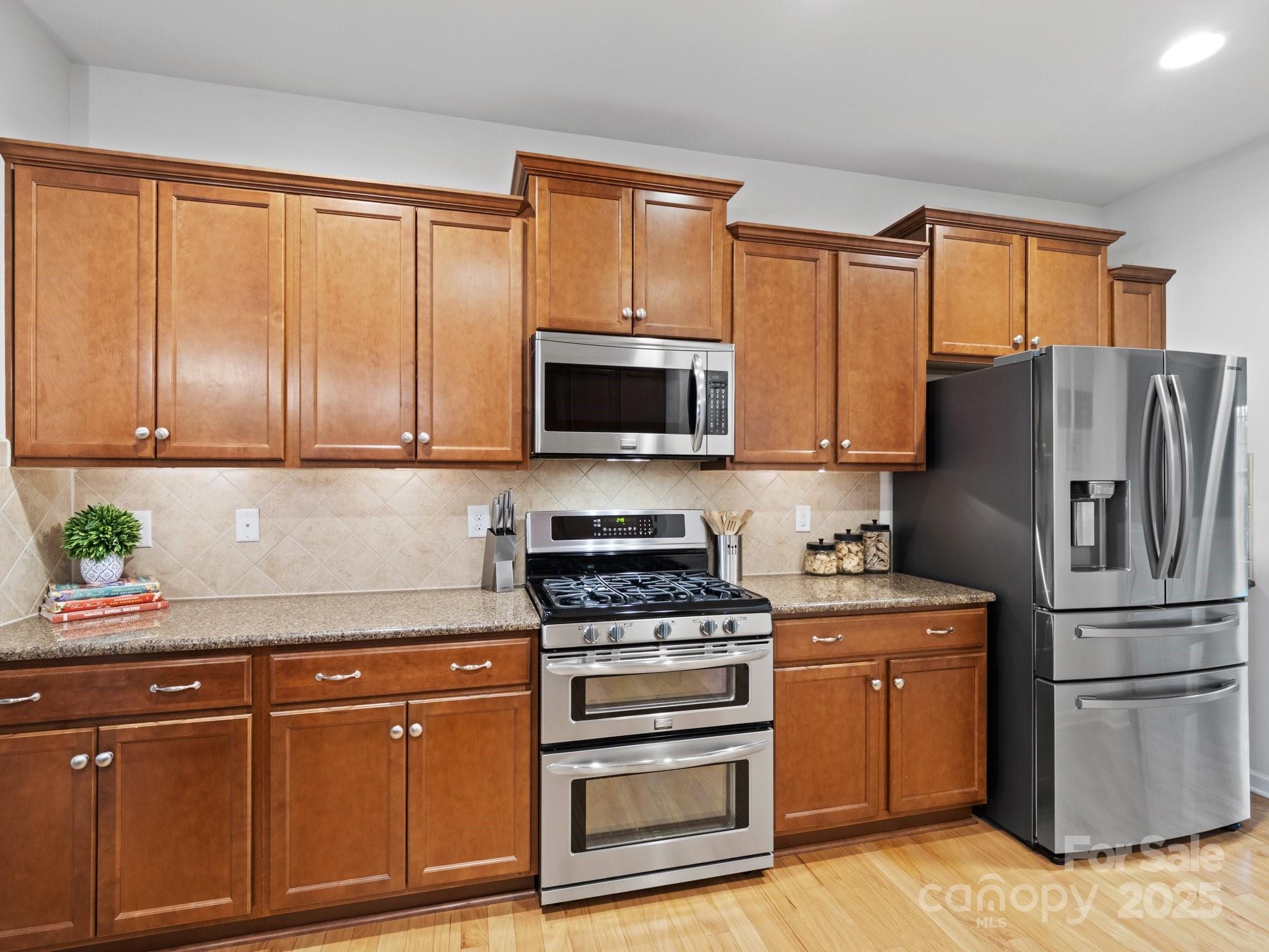 1033 Crawford Drive Lancaster, SC 29720 - Photo 18 of 48 a kitchen with granite countertop a refrigerator stove and microwave