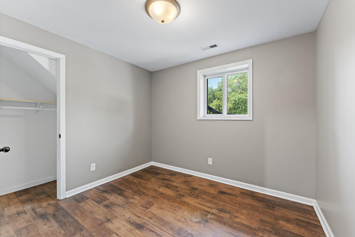 10983 Potomac Drive Demotte, IN 46310 - Photo 16 of 18 an empty room with wooden floor and windows
