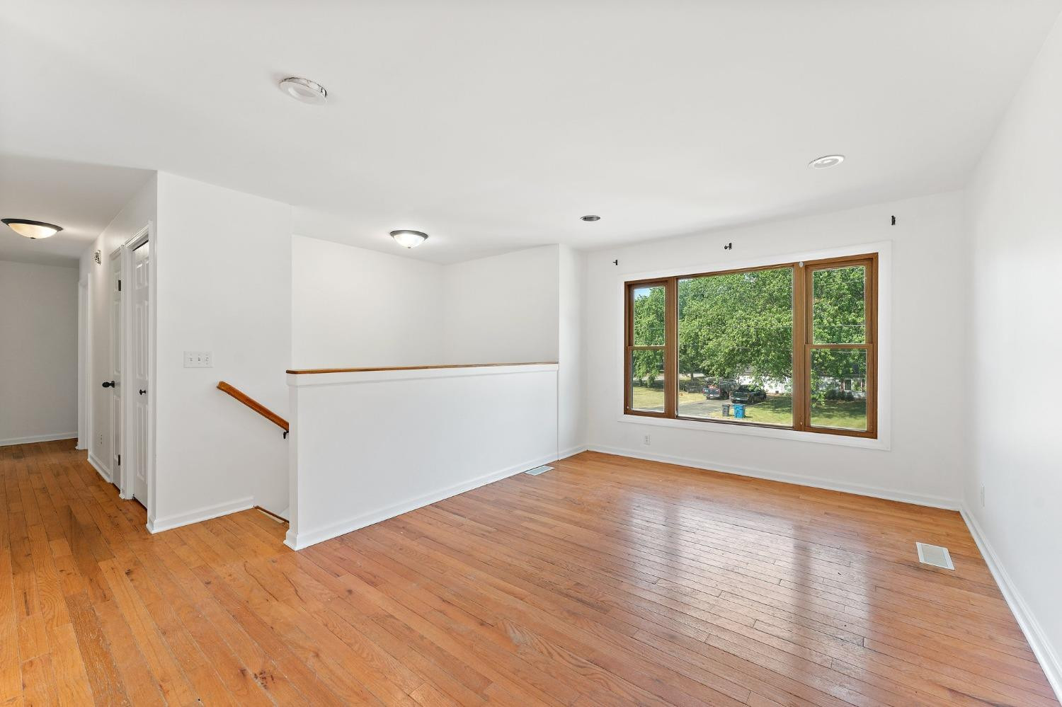 10983 Potomac Drive Demotte, IN 46310 - Photo 3 of 18 a view of an empty room with wooden floor and a window
