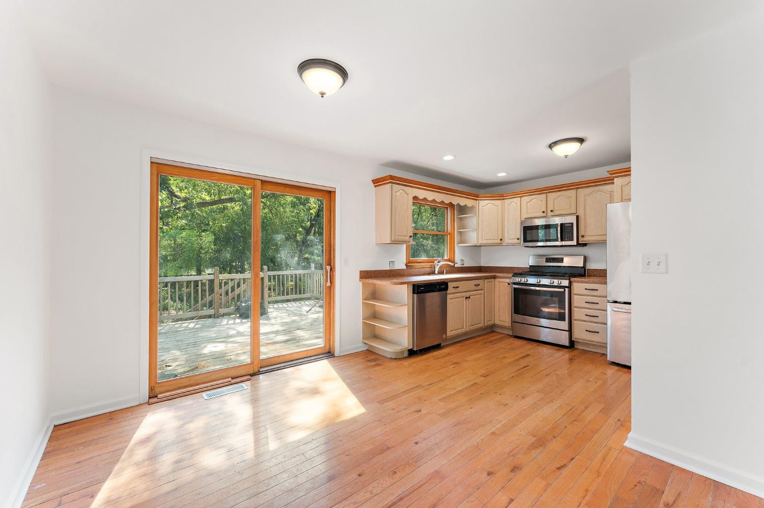 10983 Potomac Drive Demotte, IN 46310 - Photo 4 of 18 a kitchen with stainless steel appliances granite countertop a stove a sink and a refrigerator with wooden floor