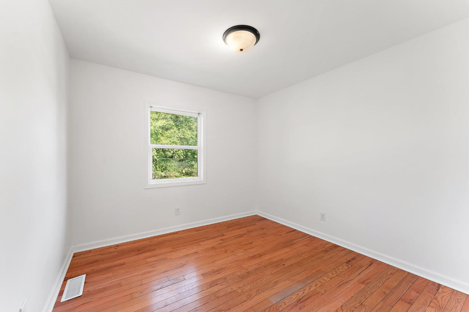 10983 Potomac Drive Demotte, IN 46310 - Photo 9 of 18 an empty room with wooden floor and windows