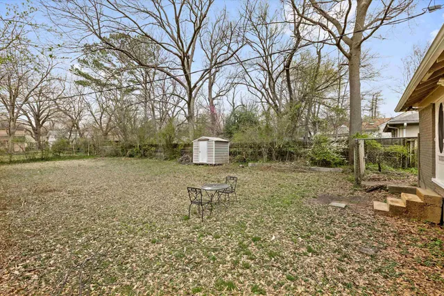 a backyard of a house with table and chairs