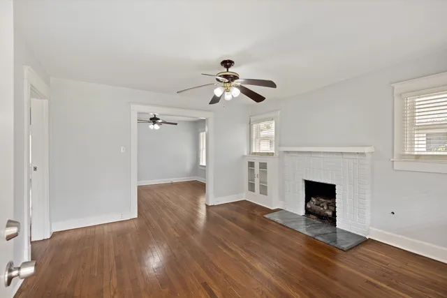 a view of empty room with wooden floor and fireplace