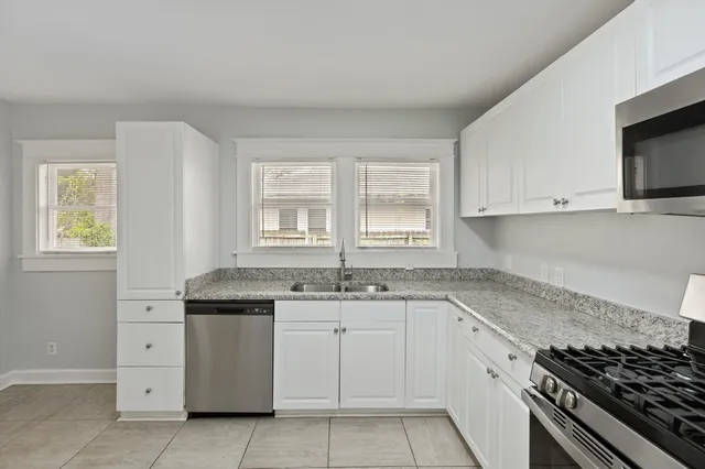 a kitchen with granite countertop white cabinets and appliances