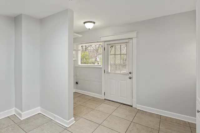 a view of an empty room with closet and a window