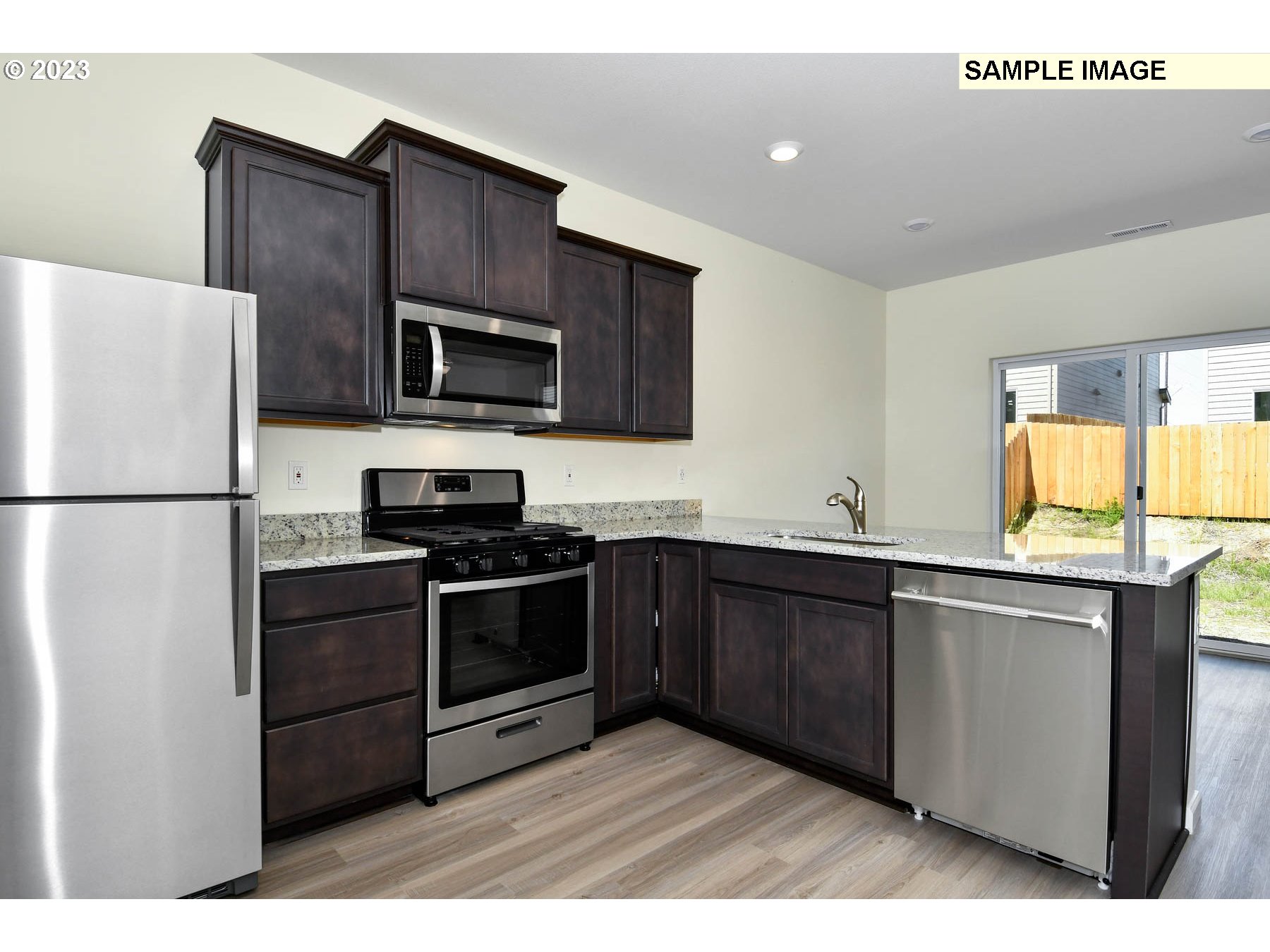 3974 Southwest Knapp Drive Gresham, OR 97080 - Photo 11 of 14 a kitchen with stainless steel appliances granite countertop a refrigerator a stove a sink and a microwave