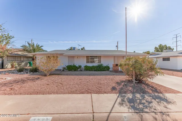 a view of a house with a yard and potted plants
