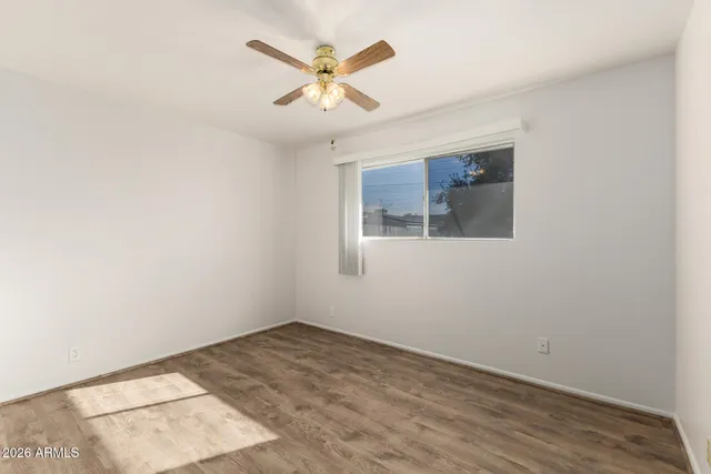 an empty room with a window and a ceiling fan