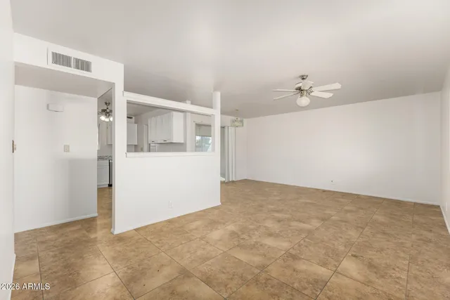an empty room with windows and ceiling fan