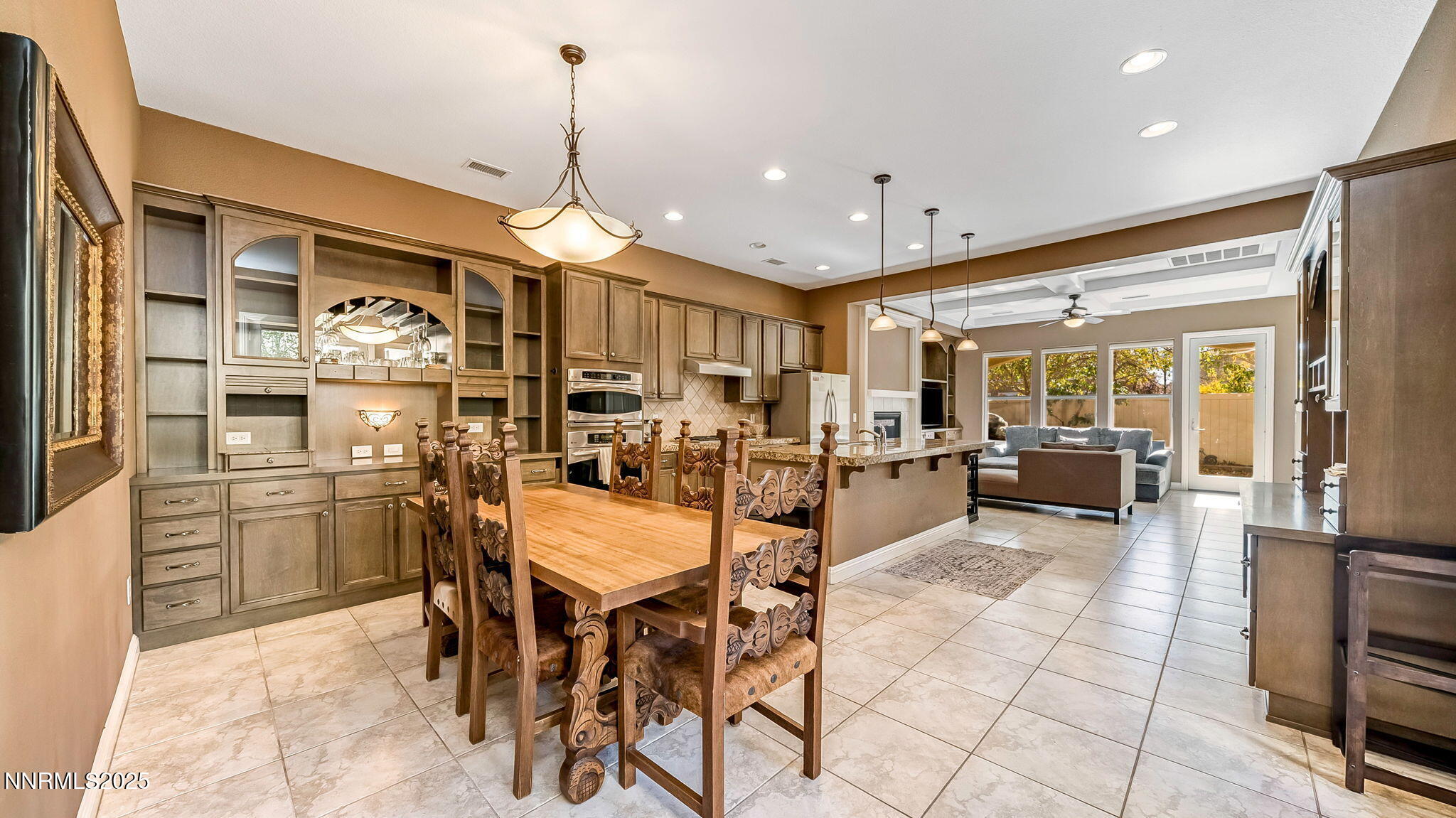 1812 Braemore Drive Reno, NV 89521 - Photo 4 of 26 a kitchen with stainless steel appliances kitchen island granite countertop a refrigerator a stove a dining table and chairs with wooden floor