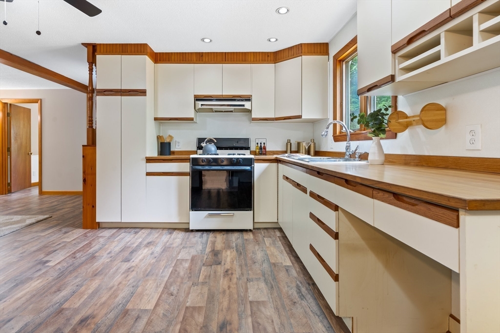 74 County Road East Freetown, MA 02717 - Photo 26 of 40 a kitchen with stainless steel appliances granite countertop a sink a stove a refrigerator and cabinets with wooden floor
