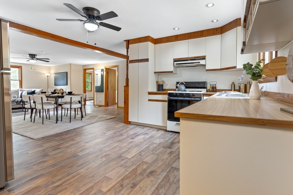 74 County Road East Freetown, MA 02717 - Photo 28 of 40 a kitchen with granite countertop a stove top oven a sink dishwasher a dining table and chairs with wooden floor