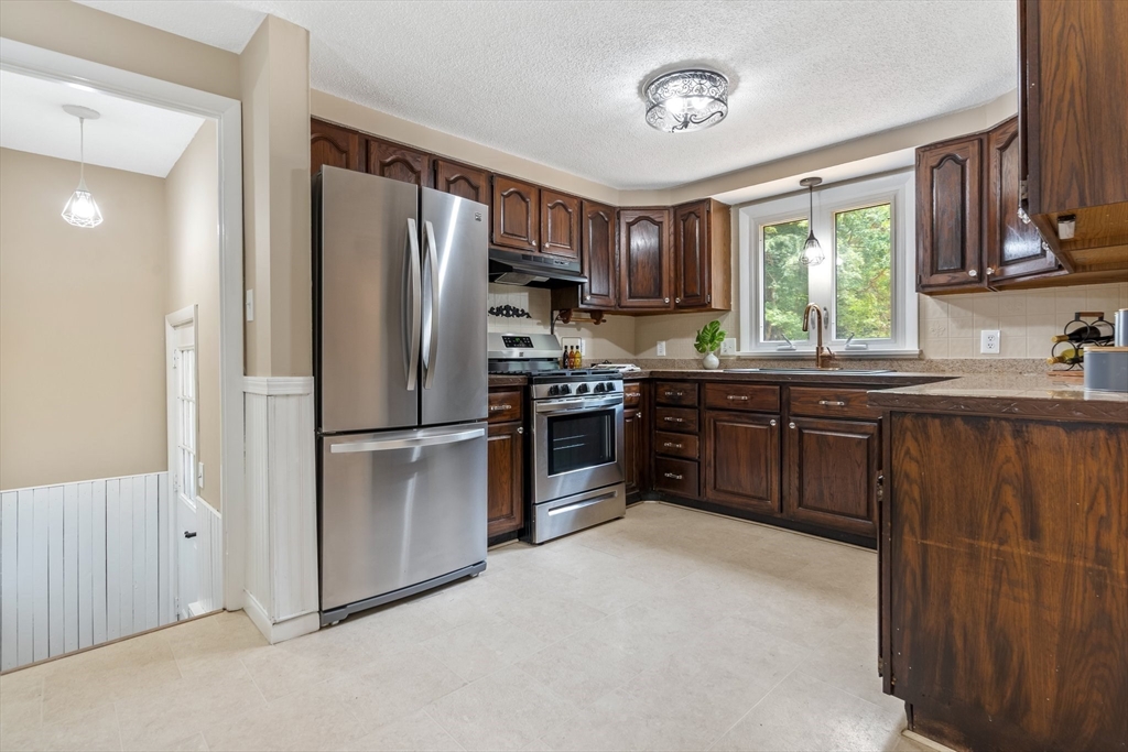 74 County Road East Freetown, MA 02717 - Photo 9 of 40 a kitchen with stainless steel appliances granite countertop a refrigerator a sink a stove and with wooden cabinets
