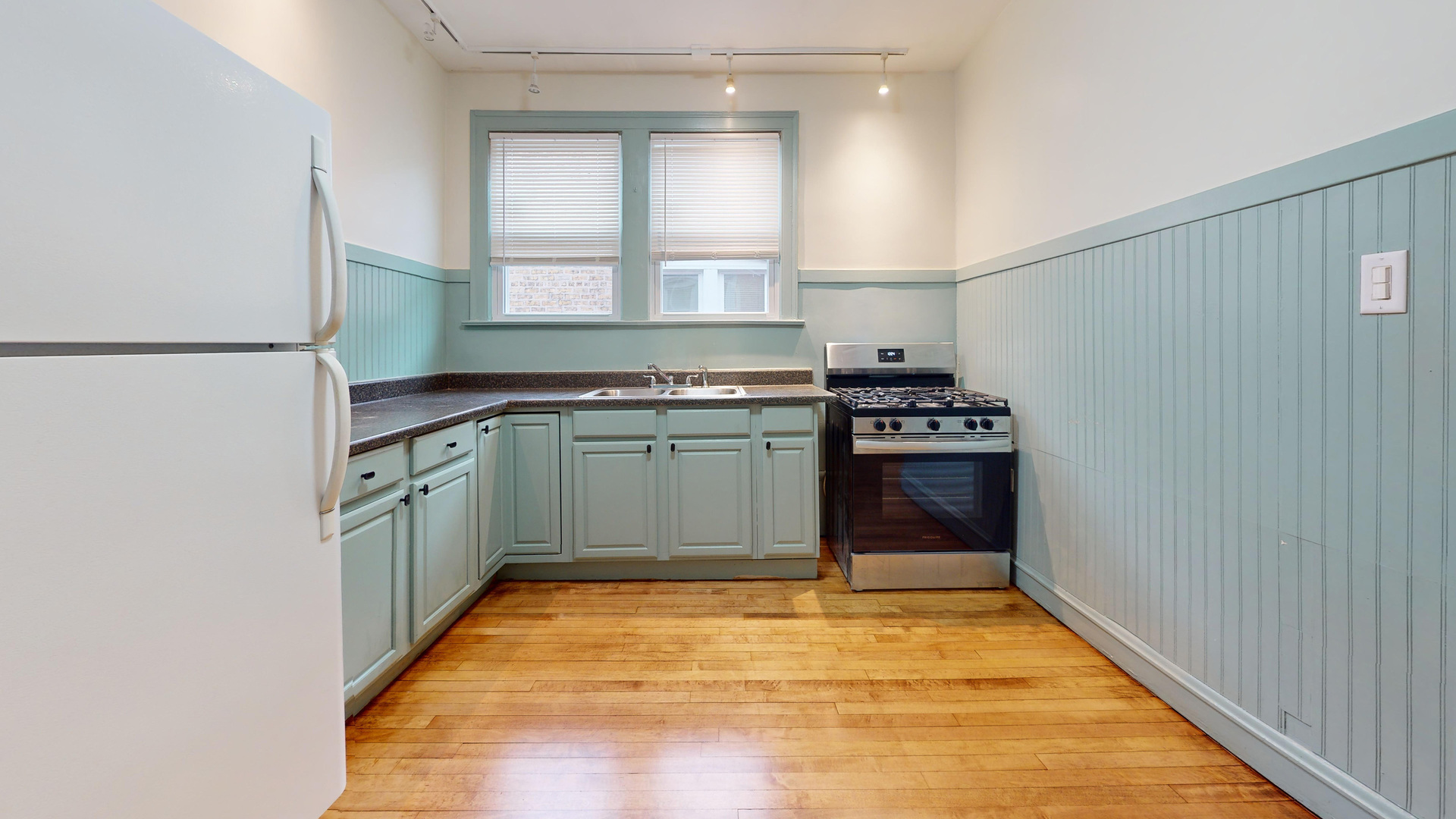 6738 North Rockwell Street, Unit 2 Chicago, IL 60645 - Photo 7 of 13 a kitchen with a sink a stove top oven and cabinets