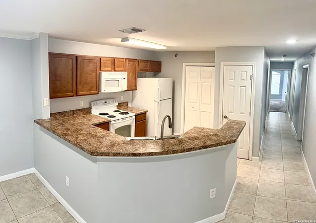 a kitchen with kitchen island granite countertop a table and chairs in it
