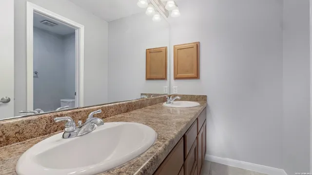 a bathroom with a granite countertop sink a large mirror and vanity