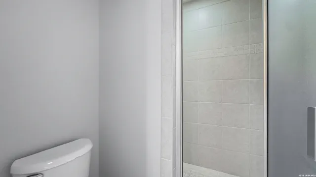 a white toilet sitting next to a shower