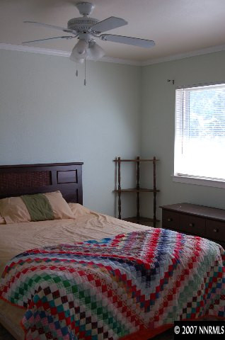 15450 Kivett Lane Reno, NV 89521 - Photo 2 of 9 a bedroom with a bed and a chandelier