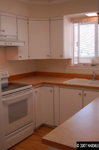 15450 Kivett Lane Reno, NV 89521 - Photo 3 of 9 a kitchen with granite countertop white cabinets and white appliances