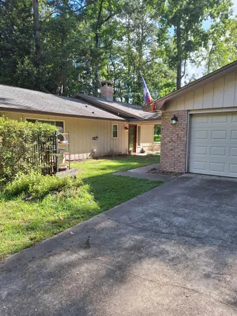 a view of a yard with a house and a large tree
