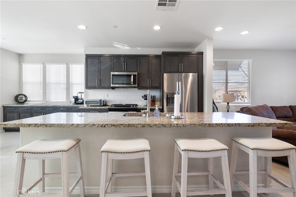 1200 Oliva Court Duarte, CA 91010 - Photo 4 of 40 a kitchen with stainless steel appliances granite countertop a sink a stove a refrigerator cabinets and chairs