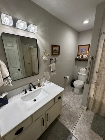 a bathroom with a sink mirror and toilet