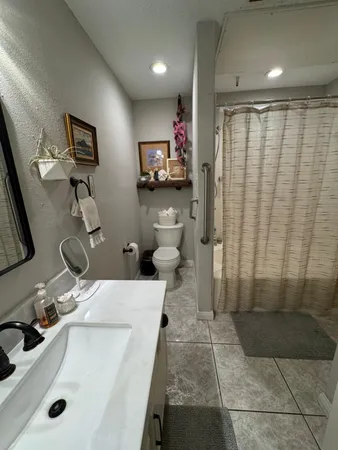 a bathroom with a sink a toilet and mirror
