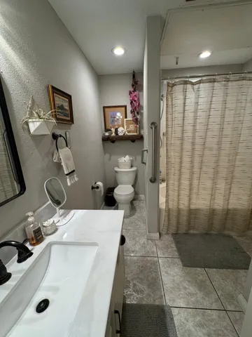a bathroom with a sink a toilet and mirror