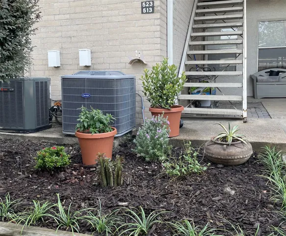 a view of a backyard with plants and chairs