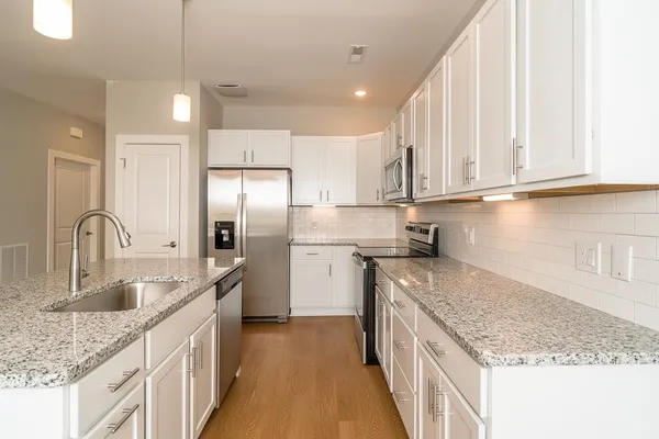 a kitchen with stainless steel appliances granite countertop a sink stove and refrigerator