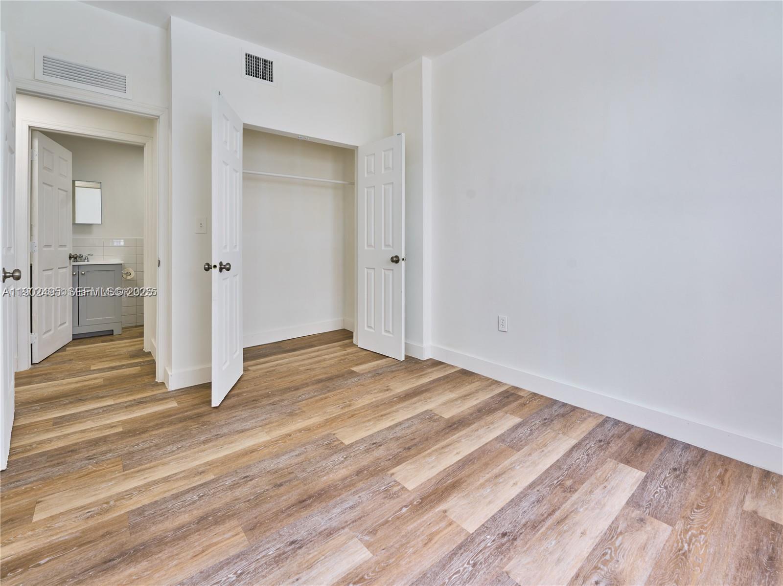 a view of empty room with wooden floor