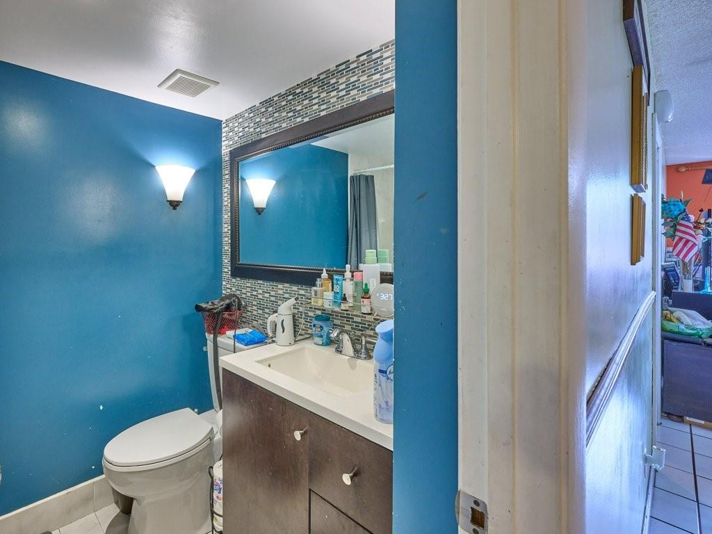 3253 Riverside Drive, Unit D301 Coral Springs, FL 33065 - Photo 14 of 29 a bathroom with a sink toilet and mirror