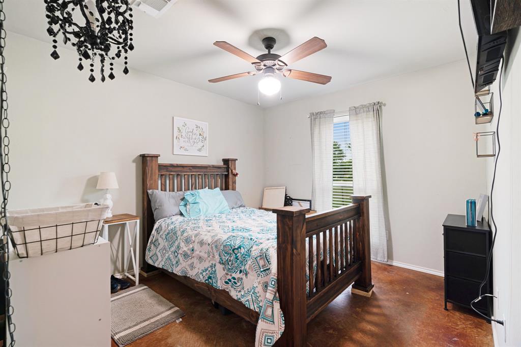 1890 County Road Sumner, TX 75486 - Photo 16 of 20 a bedroom with a bed and a chandelier