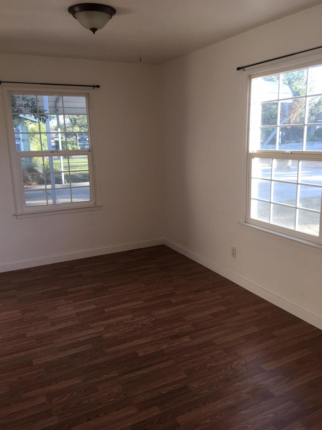 1841 Easy Street Hanford, CA 93230 - Photo 7 of 16 an empty room with wooden floor and windows