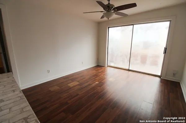 a kitchen with a wooden floor and stainless steel appliances