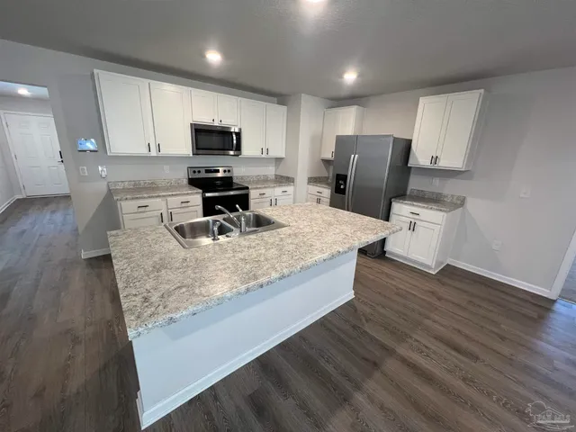 a kitchen with sink refrigerator and microwave