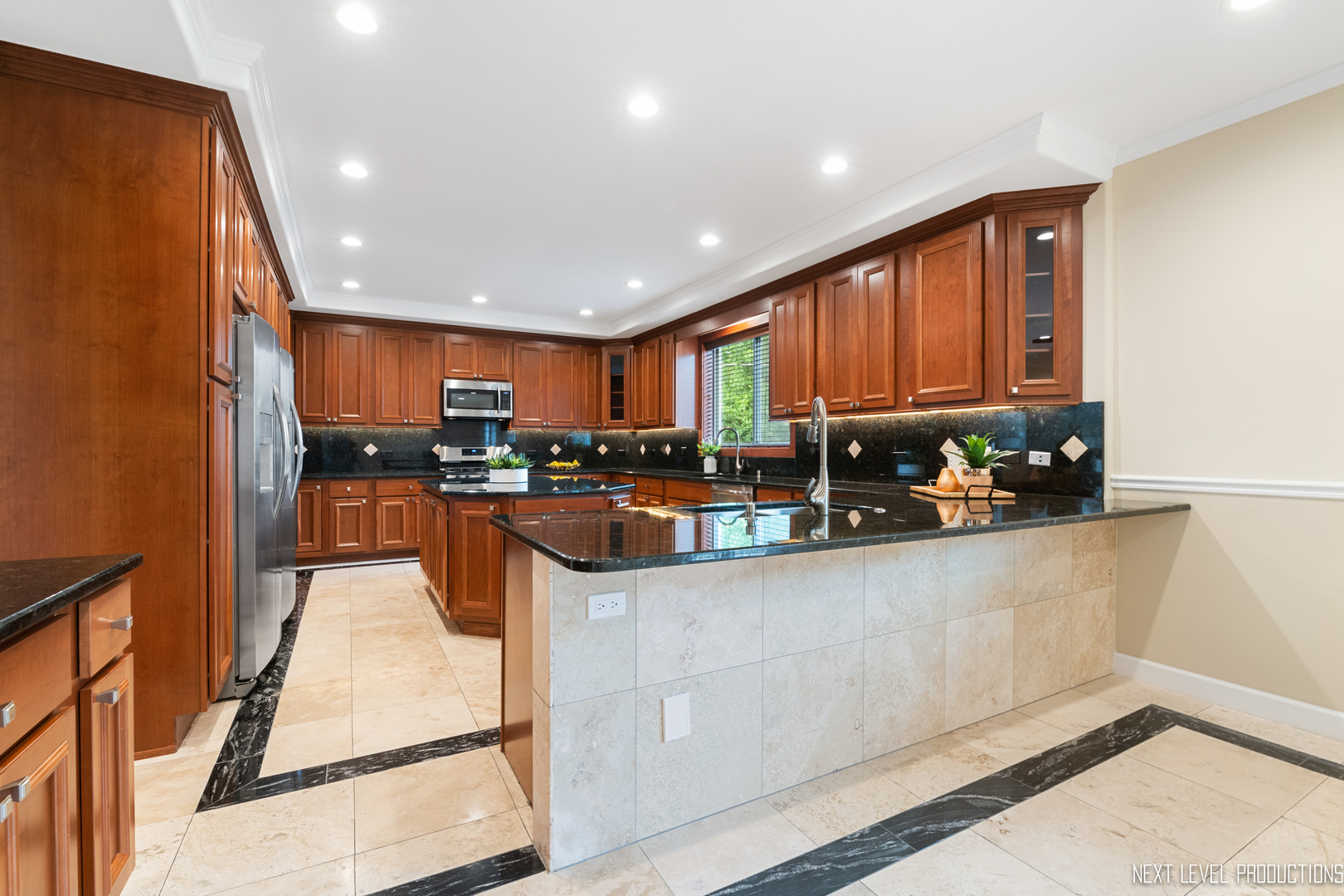 115 Birch Avenue Lake Bluff, IL 60044 - Photo 9 of 39 a kitchen with stainless steel appliances granite countertop a refrigerator a sink dishwasher a stove top oven a large island with wooden cabinets and floor