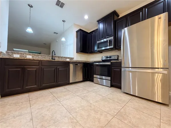 a kitchen with stainless steel appliances granite countertop a refrigerator and a sink