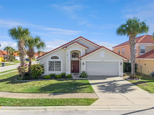 a front view of a house with a yard and potted plants