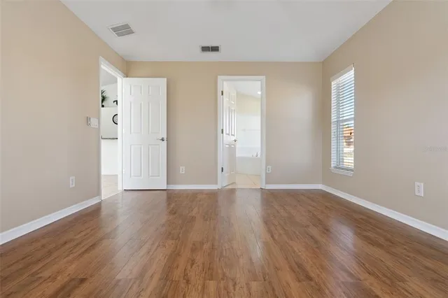 a view of a big house with a big yard and large trees