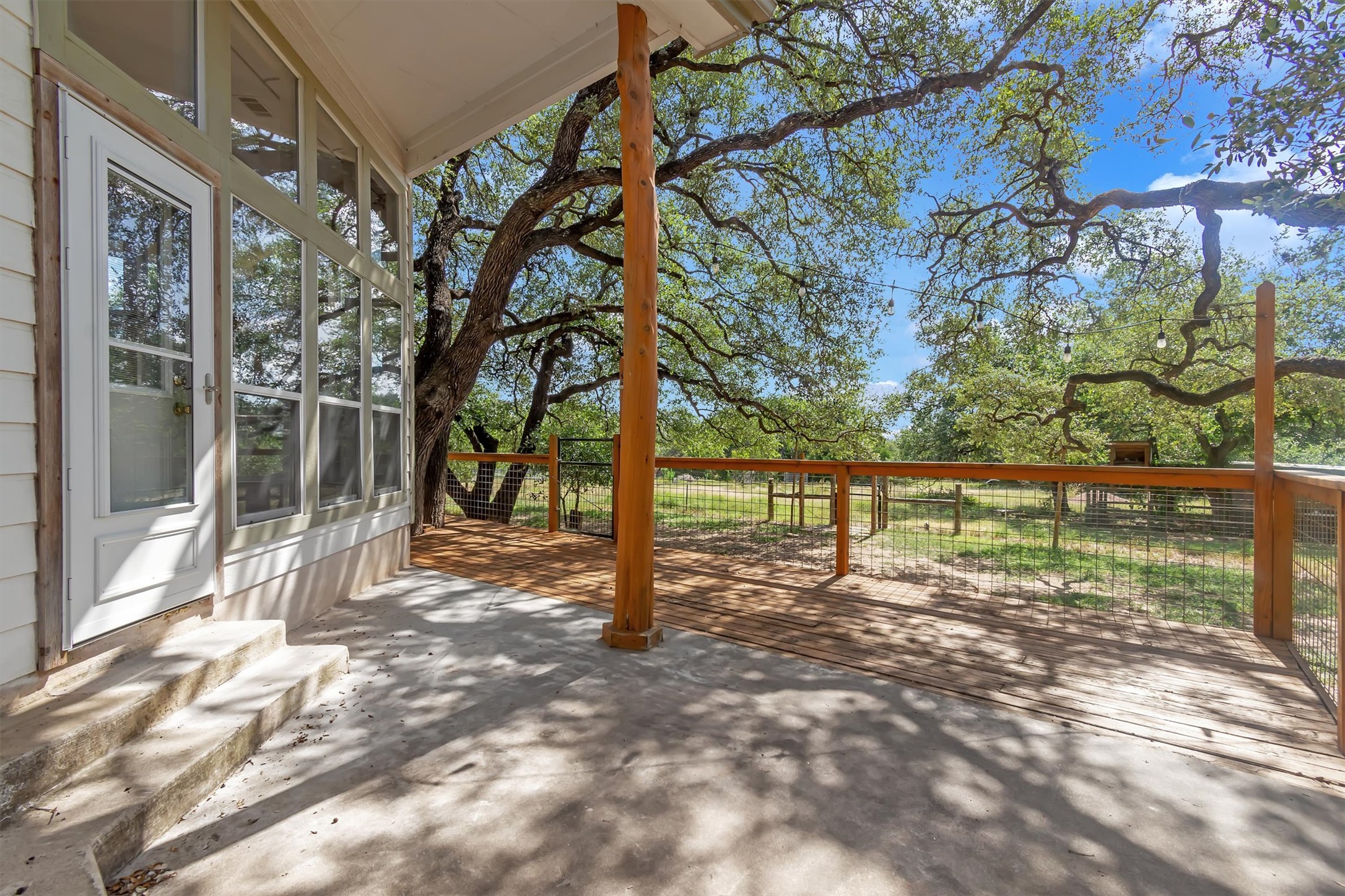 1120 Meadow Ridge Drive Austin, TX 78737 - Photo 31 of 40 A spacious wood deck extends to a natural backyard, framed by mature trees.